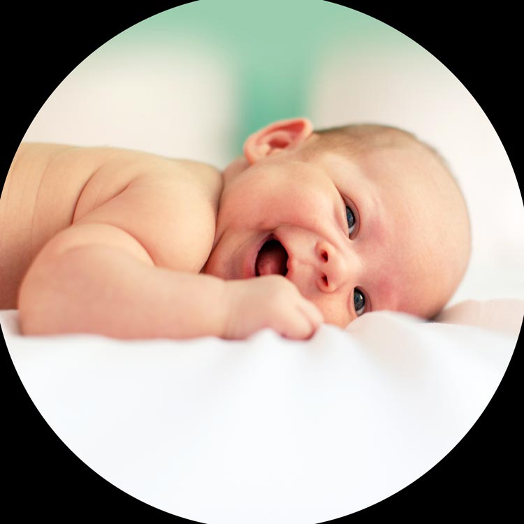 Un bébé allongé rigole